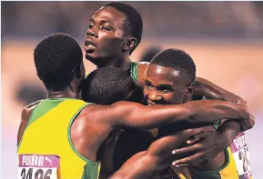  ??  ?? St Jago High’s Leon Clarke (top) is surrounded by teammates after he piloted his team to victory in the 4x800 metres for high-school boys at last month’s Gibson McCook Relays.