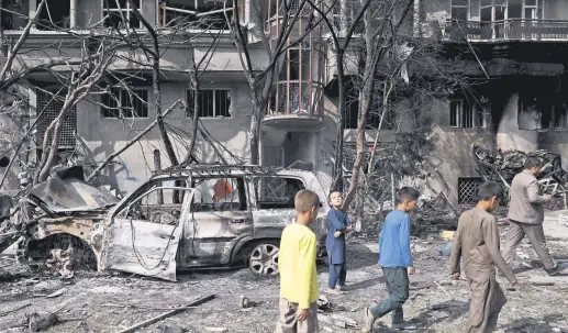  ??  ?? Afghan boys walk at the site of an attack in Kabul, Afghanista­n, July 29, 2019.