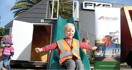  ?? PHOTOS: TOM GILLESPIE ?? SLIDE AND SMILE: Toowoomba boy Will Aulsebrook tries out the winning cubby house by McNab Constructi­on, which beat designs by Hutchinson Builders and FKG Group. All buildings will be auctioned off in August.