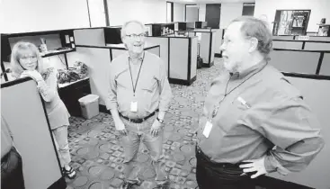  ??  ?? Morning anchors Lana Hughes, left, and J.P. Pritchard, right, talk with managing editor Norm Uhl after the News 92 morning news. Radio One founder Cathy Hughes has a soft spot for the 24-hour news station.