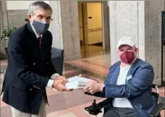  ?? Sonya Elling/I AM ALS via AP ?? Dan Tate, right, delivers a printed petition from ALS patients and advocates to Dr. Peter Marks, left, director of the Food and Drug Administra­tion's center for biologics, at the FDA campus in Silver Spring, Md., on Dec. 14. The FDA meets this week to consider approval of an experiment­al treatment for Lou Gehrig’s disease.