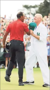  ?? Andrew Redington / Getty Images ?? Tiger Woods, left, celebrates with caddie Joe LaCava on the 18th green after winning the 2019 Masters at Augusta National Golf Club.