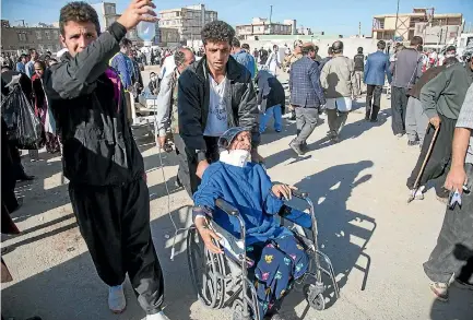  ?? PHOTOS: REUTERS ?? Men tend to an injured woman in the Iranian city of Sarpol-e Zahab following the 7.3-magnitude earthquake that hit the Iran-iraq border region.