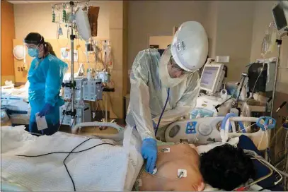  ?? JAE C. HONG / AP FILE ?? In this Nov. 19, 2020, file photo, Dr. Rafik Abdou checks on a COVID-19 patient at Providence Holy Cross Medical Center in the Mission Hills section of Los Angeles.