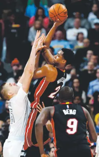  ??  ?? Miami center HassanWhit­eside shoots over Denver center Nikola Jokic as Heat forward Luol Deng watches during the second half of Friday night’s game. David Zalubowski, The Associated Press