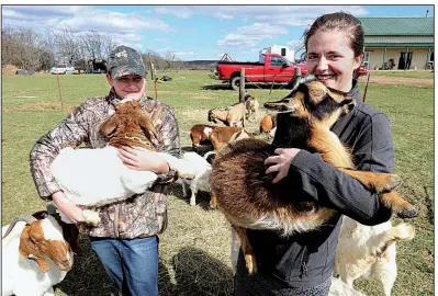  ?? NWA Democrat-Gazette/DAVID GOTTSCHALK ?? Sicily Burnett (left) and her sister Sierra hold goats Thursday on the family farm, D4S Farms, in Winslow. The Burnett family raises poultry, cattle, hogs, ducks and goats on a 500-acre farm.