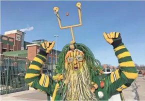  ?? MIKE DE SISTI / MILWAUKEE JOURNAL SENTINEL ?? Rob Roskom of Seymour is decked out in all kinds of green and gold, topped off with a goal post on his head, for the Packers-Giants game.