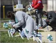  ??  ?? Rachael Cohen Hamilton, front, a grant writer for Safe Berks, sets up pinwheels with other staff members at Safe Berks in Reading Friday afternoon April 2, 2021. The staff members put out 250 pinwheels to symbolize local victims of sexual assault as part of their event, “Recognizin­g & Rememberin­g Victims of Sexual Assault – Known & Unknown,” during Sexual Assault Awareness Month.