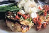  ??  ?? The chicken Henry is grilled and topped with goat cheese, sun-dried tomatoes, basil and a lemon butter sauce.