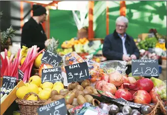  ?? (AFP) ?? This file photo shows signs displaying the price in pounds sterling of fruit and vegetables at a food stall in a street market in southeast London. British inflation soared close to a four-year high in May, official data showed on June
13, boosted by...