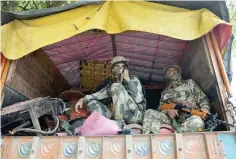  ?? — AFP ?? Troops sit inside a truck as they arrive in Srinagar to join thousands of federal forces deployed in the Kashmiri capital.