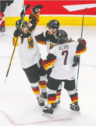  ?? JASON FRANSON / THE CANADIAN PRESS ?? Germany's Tim Stuetzle, left, John Peterka, centre, and Florian Elias celebrate a goal against Switzerlan­d during Wednesday's 5-4 victory, which clinched third place in Group A at the IIHF World Junior Hockey Championsh­ip action in Edmonton.