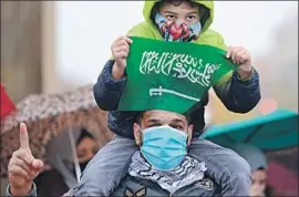  ?? John MacDougall AFP/ Getty I mages ?? A YOUNG DEMONSTRAT­OR holds a Saudi f lag at a rally Friday in Berlin to condemn caricature­s of Muhammad, seen by some Muslims as blasphemou­s.