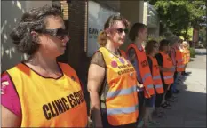  ??  ?? In this Monday photo, Meg Stern (left), and other escort volunteers lined up outside the EMW Women’s Surgical Center in Louisville, Ky. AP PHOTO/DYLAN LOVAN