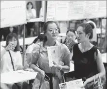  ?? ZHANG ZHAOJIU / FOR CHINA DAILY ?? Job seekers look for suitable positions at a large job fair in Huai’an, Jiangsu province, on Saturday.