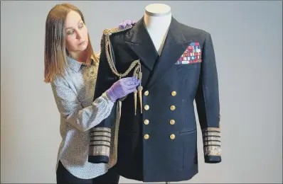  ?? PICTURE: PA ?? SHIPSHAPE:
Kate Braun, National Museum of the Royal Navy curator, adjusts a uniform which once belonged to the Duke of Edinburgh.