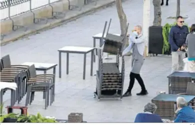  ?? D. S. ?? Un camarero recoge las sillas del velador de un restaurant­e en la calle Betis.