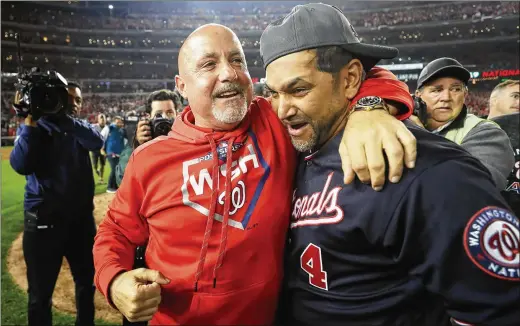  ?? ROB CARR / GETTY IMAGES ?? Manager Dave Martinez gets a hug from general manager Mike Rizzo after the clinching win in the playoff sweep of the Cardinals. En route to the World Series, the Nationals overcame a 19-31 start, and Martinez, 55, had a health scare in September but rejoined the club before doctors had cleared him.