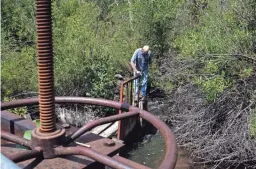  ?? MARK HENLE/THE REPUBLIC ?? Water Commission­er James Holiman closes a diversion gate at the beginning of the Big Ditch in Colorado in August.