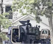  ?? BILL LACKEY / STAFF ?? Members of the Springfiel­d Police Division surround a house on Fair Street at the South Lowry Avenue intersecti­on Monday.