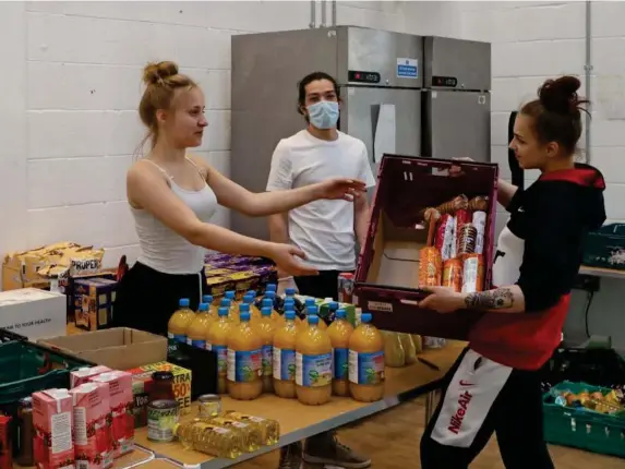  ?? (Nigel Howard) ?? Volunteers in South Acton help pack boxes for the project