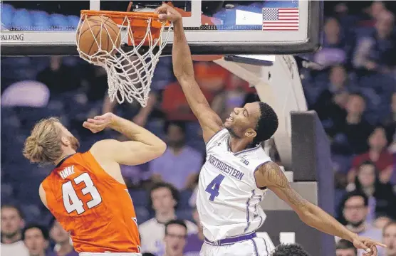  ?? | NAM Y. HUH/ AP ?? Northweste­rn forward Vic Law, who finished with 16 points, hits one of his dunks over Illinois forward Michael Finke in the first half Friday at Allstate Arena.