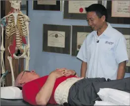  ??  ?? Dr. Michael Ho consults with a patient suffering with herniated disc, degenerate­d disc, and back pain for over 10 years.