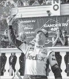  ?? DERIK HAMILTON/AP ?? Denny Hamlin celebrates after winning Sunday’s Cup race at Pocono Raceway.