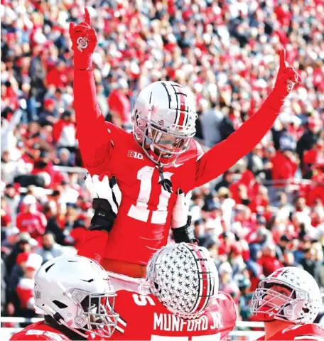  ?? AP PHOTO/JAY LAPRETE ?? Ohio State receiver Jaxon Smith-Njigba, top, celebrates his touchdown against Michigan State during the first half Saturday in Columbus, Ohio. The fifth-ranked Buckeyes rolled to a 56-7 victory over the No. 7 Spartans, who were eliminated from the Big Ten title chase.