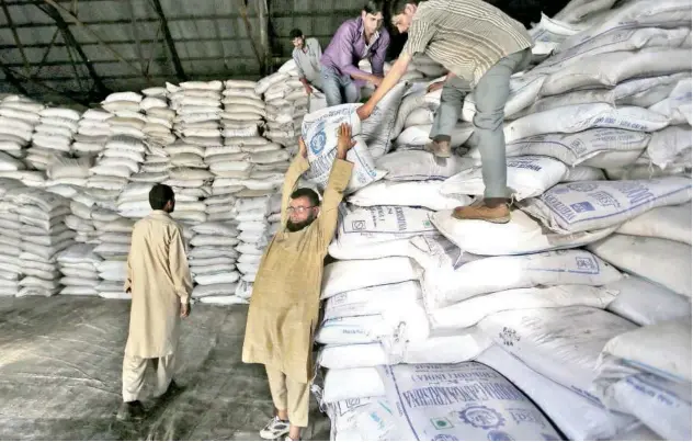  ?? File/reuters ?? ↑
Workers stack sugar sacks inside a warehouse in Srinagar, India.