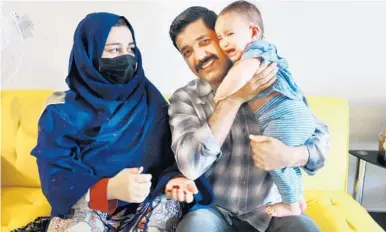  ?? By Kate Santich STEPHEN M. DOWELL/ORLANDO SENTINEL ?? Mohebullah Zyarmal is pictured with his wife and daughter at their home in Orlando on Monday. Zyarmal, from Afghanista­n, previously worked with the U.S. military as a translator. He fled the country when the U.S. withdrew its troops.