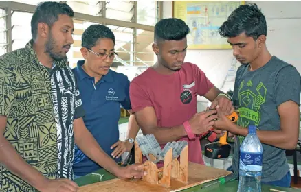  ?? Photo: Fiji National University ?? Kite Lagicere (second from left) looks on as students of her Automotive Engineerin­g class work on a model.