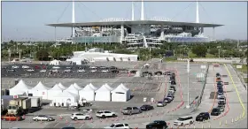  ?? WILFREDO LEE — THE ASSOCIATED PRESS ?? Cars line up at a drive-thru coronaviru­s testing site in front of Hard Rock Stadium in Miami Gardens, Fla on March 30.