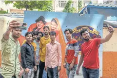  ?? ?? Fans take selfies with a DDLJ movie poster.