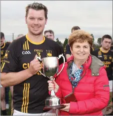  ??  ?? Adamstown captain Colm Boland receiving the cup from Mary Foley.