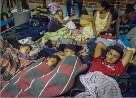  ?? DANIELE VOLPE / THE NEW YORK TIMES ?? Honduran migrants rest Oct. 17 at a church-run shelter in Guatemala City. As many as 4,000 people are walking together north from Central America, fleeing violence or poverty. President Donald Trump wants them to stop.