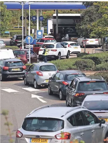  ?? FOTO: ADRIAN DENNIS/AFP ?? Autofahrer stehen am Sonntag vor einer Tankstelle in Camberley, westlich von London, in der Schlange, weil sie befürchten, kein Benzin mehr zu erhalten.