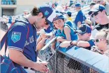  ?? FRANK GUNN
THE CANADIAN PRESS FILE PHOTO ?? Toronto Blue Jays fielder Randal Grichuk signs autographs for fans. Grichuk is out with sore ribs but is beginning to swing the bat again.