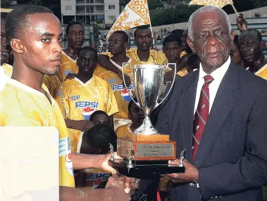  ?? FILE ?? Livingston Scott/Gleaner Writer Ben Francis (right) presenting the trophy named in his honour, the Ben Francis KO Cup, to Ashton Bennett, captain of 2007 champions Garvey Maceo High.