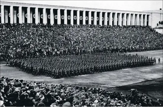  ?? FPG / GETTY ?? Desfile militar ante la tribuna de Zeppelinfe­ld en septiembre de 1936. Al lado, lo que queda de la tribuna en la actualidad, con el balcón central desde el
que hablaba Hitler