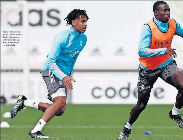  ??  ?? Mendy conduce un balón junto a Víctor Rofino durante el entrenamie­nto del Real Madrid ayer en Valdebebas.