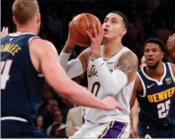  ?? Luis Sinco / Los Angelestim­es /TNS ?? The Los Angeles Lakers’ Kyle Kuzman goes to the basket against the Denver Nuggets’ Mason Plumlee (left) on Dec. 22, 2019, at Staples Center in Los Angeles.