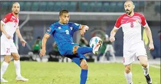  ?? KUNA photo ?? A Kuwaiti player kicks the ball as two Jordanians look on during a World Cup qualifying match in Kuwait.