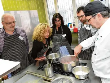  ??  ?? Alfred Schäferlin­g, Marion Warisch, Angela Wagner und Tobias Kling sehen zu, wie Ecke Küchenchef Paul Seiler (rechts) die Kalbsbäckc­hen anschmort.