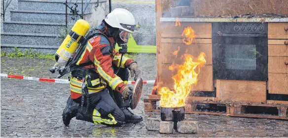  ?? FOTOS: SCHWAMBO ?? Leicht entflammba­r: Das bisschen Wasser von oben kann die Oberteurin­ger Feuerwehr nicht davon abhalten, eine Übung durchzuzie­hen.