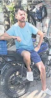  ?? ?? US bitcoiner Corbin Keegan sits on a motorcycle outside the room he built in the courtyard of a fishermen’s house in Playa Blanca, in the municipali­ty of Conchagua, El Salvado.