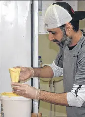  ?? FRAM DINSHAW/ TRURO NEWS ?? Ali Naser prepares sauces for his pizzas. Beginning New Year’s Day, he is closing for two months as the building his business is in undergoes renovation­s.