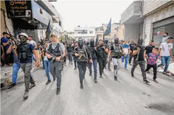  ?? Majdi Mohammed/Associated Press ?? Armed Palestinia­ns march in a funeral procession in the city of Jenin after Israeli soldiers shot and killed two people in an exchange of fire that erupted during a raid in the West Bank town.