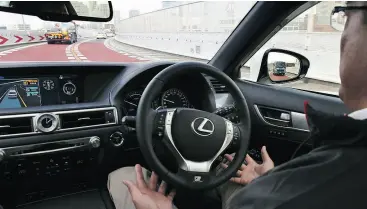  ?? KOJI SASAHARA / THE ASSOCIATED PRESS ?? A Toyota employee in an automated driving test vehicle. Toyota unveiled its vision for self- driving cars, promising to start selling such vehicles in Japan by 2020.