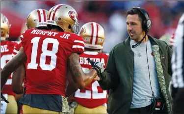  ?? PHOTOS BY NHAT V. MEYER/TRIBUNE NEWS SERVICE ?? Above: San Francisco 49ers head coach Kyle Shanahan high-fives Louis Murphy (18) after the 49ers scored a touchdown against the New York Giants on Nov. 12, 2017 in Santa Clara. Below: 49ers starting quarterbac­k Jimmy Garoppolo throws against the Jacksonvil­le Jaguars on Dec. 24, 2017 in Santa Clara.